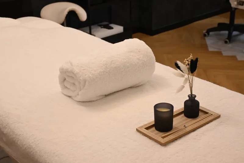 Table de massage prête, serviette moelleuse et bougie
